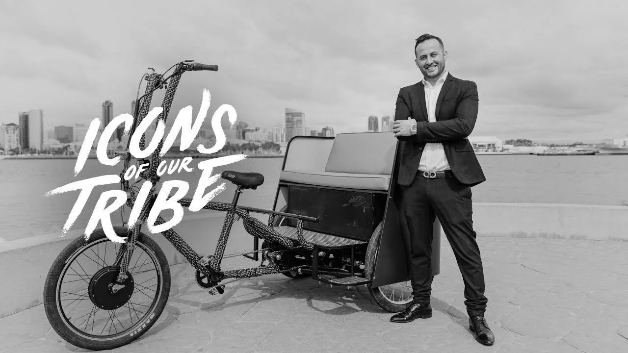 Ali Horuz standing beside a pedicab on the San Diego waterfront